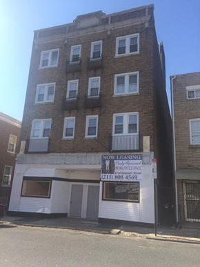 Philadelphia apartment for rent - A building with a sign that says "Now Leasing" is in front of another building.