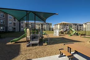 Austin apartment for rent - A playground with a green slide and a wooden bench.