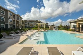 Austin apartment for rent - A large swimming pool surrounded by sun loungers and apartment buildings.