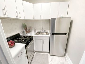 Chicago apartment for rent - a white kitchen with a refrigerator and a sink