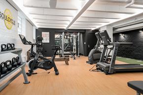 Chicago apartment for rent - A gym with a variety of equipment including a rowing machine, a bench press, and a leg press.