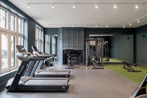 Chicago apartment for rent - A gym with treadmills, weights, and a bench press.
