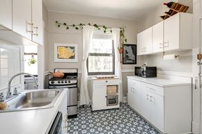 Chicago apartment for rent - a kitchen with white cabinets and a sink and a window