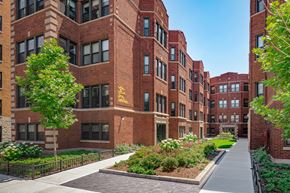 Chicago apartment for rent - a sidewalk in front of a large brick building