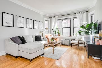 Chicago apartment for rent - a living room with white furniture and a large window