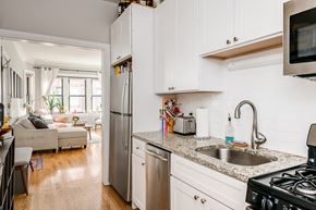 Chicago apartment for rent - a kitchen with white cabinets and granite counter tops and a sink