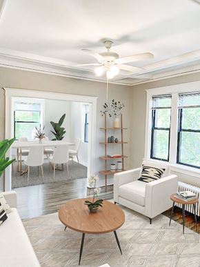 Chicago apartment for rent - A living room with a white couch, a wooden coffee table, and a ceiling fan.
