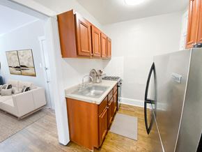 Chicago apartment for rent - A kitchen with wooden cabinets and a stainless steel refrigerator.