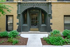 Chicago apartment for rent - the front door of a building with a sidewalk and plants