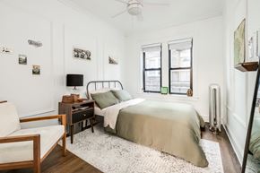 Chicago apartment for rent - a bedroom with a bed and a desk and two windows