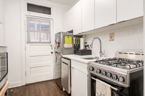 Chicago apartment for rent - a kitchen with white cabinets and a stove and a refrigerator