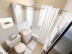 Chicago apartment for rent - A white bathroom with a toilet, sink, and shower.