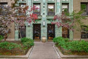 Chicago apartment for rent - A green building with a black gate and a large door.