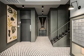 Chicago apartment for rent - a hallway with stairs and a checkered floor and a view of a hallway