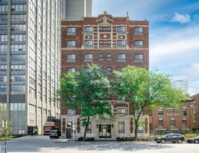 Chicago apartment for rent - a tall brick building with trees in front of a street