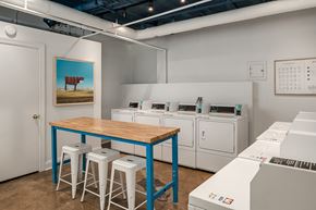 Chicago apartment for rent - a laundry room with a table and stools and washing machines