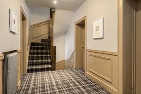 Chicago apartment for rent - A hallway with a staircase and a wall-mounted clock.