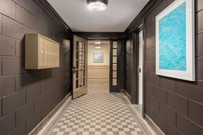 Chicago apartment for rent - A hallway with brown tiled walls and a checkered floor.