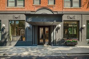 Chicago apartment for rent - A building with a grey facade and a black awning.