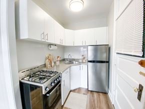 Chicago apartment for rent - A kitchen with a stove, refrigerator, and cabinets.