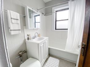 Chicago apartment for rent - A white bathroom with a toilet, sink, and bathtub.