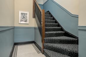 Chicago apartment for rent - a staircase with carpeted steps and blue walls and a wooden door