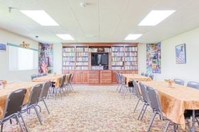 Port Charlotte apartment for rent - large community room with tables, chairs, TV, and many shelves of books