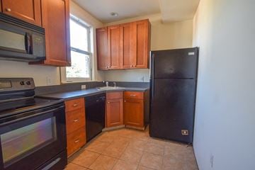 Richmond apartment for rent - a kitchen with black appliances and wooden cabinets