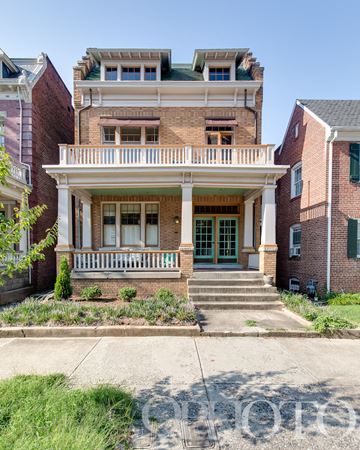 Richmond apartment for rent - an old brick house with a balcony and a porch