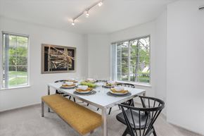 West Bloomfield apartment for rent - A dining room with a white table set for two with a painting hanging on the wall.