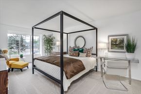 West Bloomfield apartment for rent - A bedroom with a four-poster bed and a yellow chair.