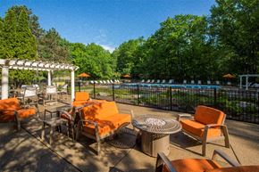 West Bloomfield apartment for rent - a patio with chairs and tables next to a swimming pool