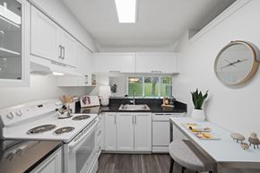 Farmington Hills apartment for rent - A modern kitchen with white cabinets and a black countertop.