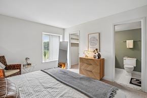 Farmington Hills apartment for rent - A bedroom with a bed, chair, and a dresser.