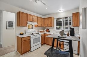 Farmington Hills apartment for rent - A kitchen with wooden cabinets and a white stove top oven.