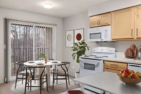 Farmington apartment for rent - A kitchen with a table and chairs in front of a window.