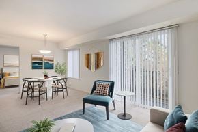 Farmington apartment for rent - A living room with a blue chair and a white table.