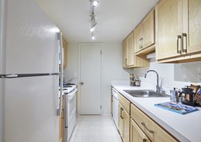 Farmington apartment for rent - a kitchen with white appliances and wooden cabinets