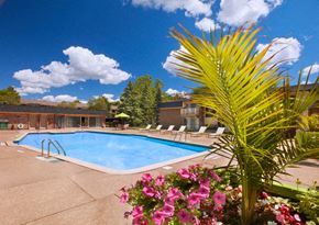Farmington apartment for rent - a pool with chairs around it in front of a building