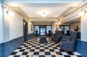 San Francisco apartment for rent - A black and white checkered floor in a room with grey chairs.