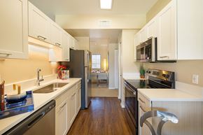 Oro Valley apartment for rent - A kitchen with white cabinets and black appliances.