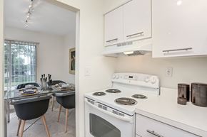 Novi apartment for rent - A white stove is in a kitchen with white cabinets.