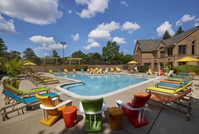 Novi apartment for rent - A pool surrounded by colorful chairs and umbrellas.