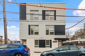 Philadelphia apartment for rent - a white and black building with cars parked in front of it