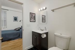 Philadelphia apartment for rent - a bathroom with a toilet sink and mirror and a bedroom with a bed