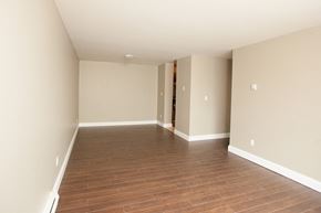 Kingston apartment for rent - an empty living room with wood flooring and white walls