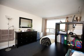 Kingston apartment for rent - a bedroom with a bed and a black dresser