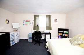 Kingston apartment for rent - a bedroom with a bed and a desk and a chair