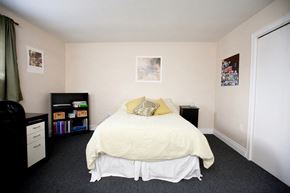 Kingston apartment for rent - a bedroom with a bed and a dresser and a window