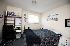 Kingston apartment for rent - a bedroom with a bed and a desk and a window
